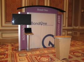 RENTAL Exhibit -- Pavilion with multiple 10&rsquo; exhibits, arch-shape canopies with black covers, Sintra accent wings, tapered counter workstations, 16&rsquo; high exhibits, kiosks -- Image 3