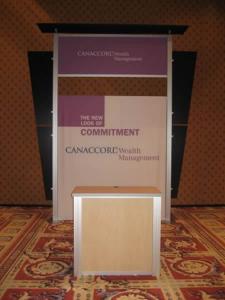 RENTAL Exhibit -- Pavilion with multiple 10&rsquo; exhibits, arch-shape canopies with black covers, Sintra accent wings, tapered counter workstations, 16&rsquo; high exhibits, kiosks -- Image 4