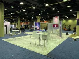 RENTAL: RE-9049 Island Design with Direct Print Sintra Graphics, Large Monitor Mount and 55" Monitor, Attached Tower Counter, and Client&rsquo;s Existing Reception Counter.