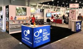 RENTAL: Gravitee Inline Design with Storage Closet with Locking Door, Bump-Out, Large Monitor Mount, 43" Monitor, (3) White Laminated Shelves, (2) LED Arm Lights, Custom Mounting for Client&rsquo;s Lightbox, (2) RE-1572 Backlit L-Shape Counters, RE-704 Chargi